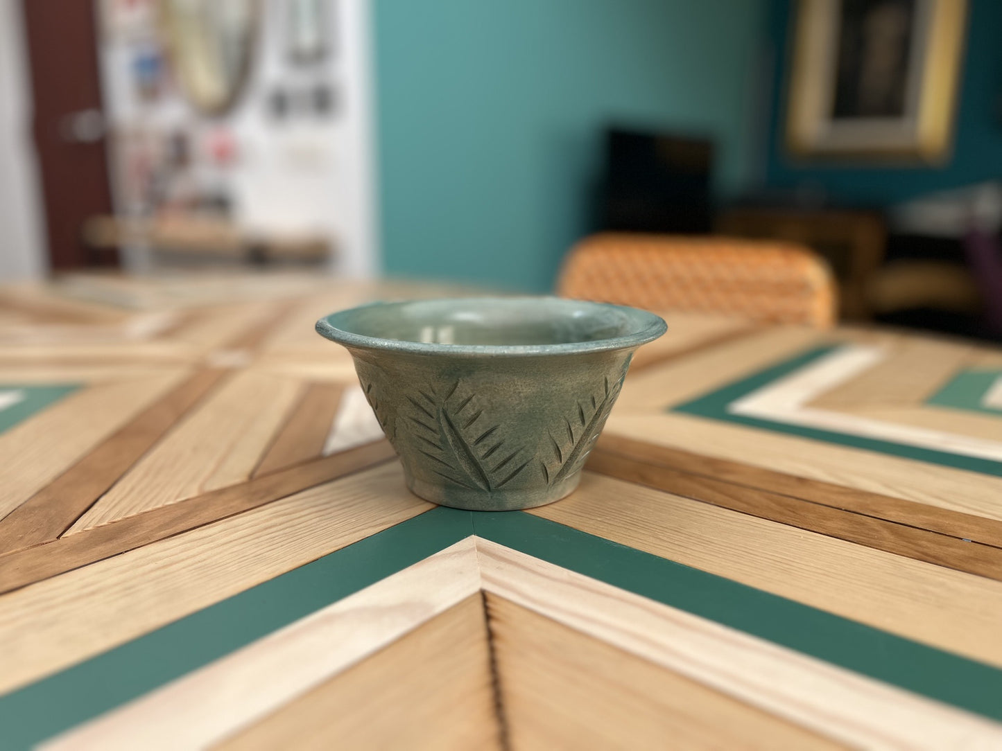 Maceta artesanal verde con decoración floral