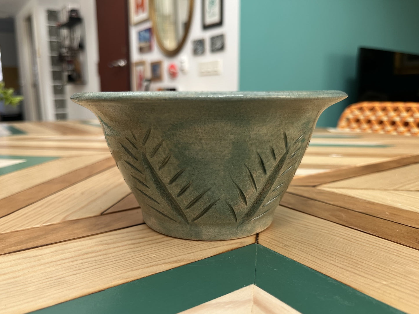 Maceta artesanal verde con decoración floral