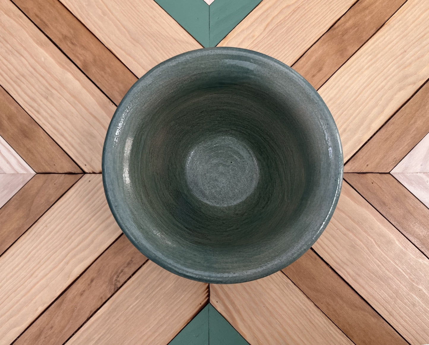 Maceta artesanal verde con decoración floral