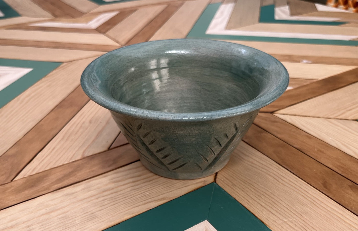 Maceta artesanal verde con decoración floral