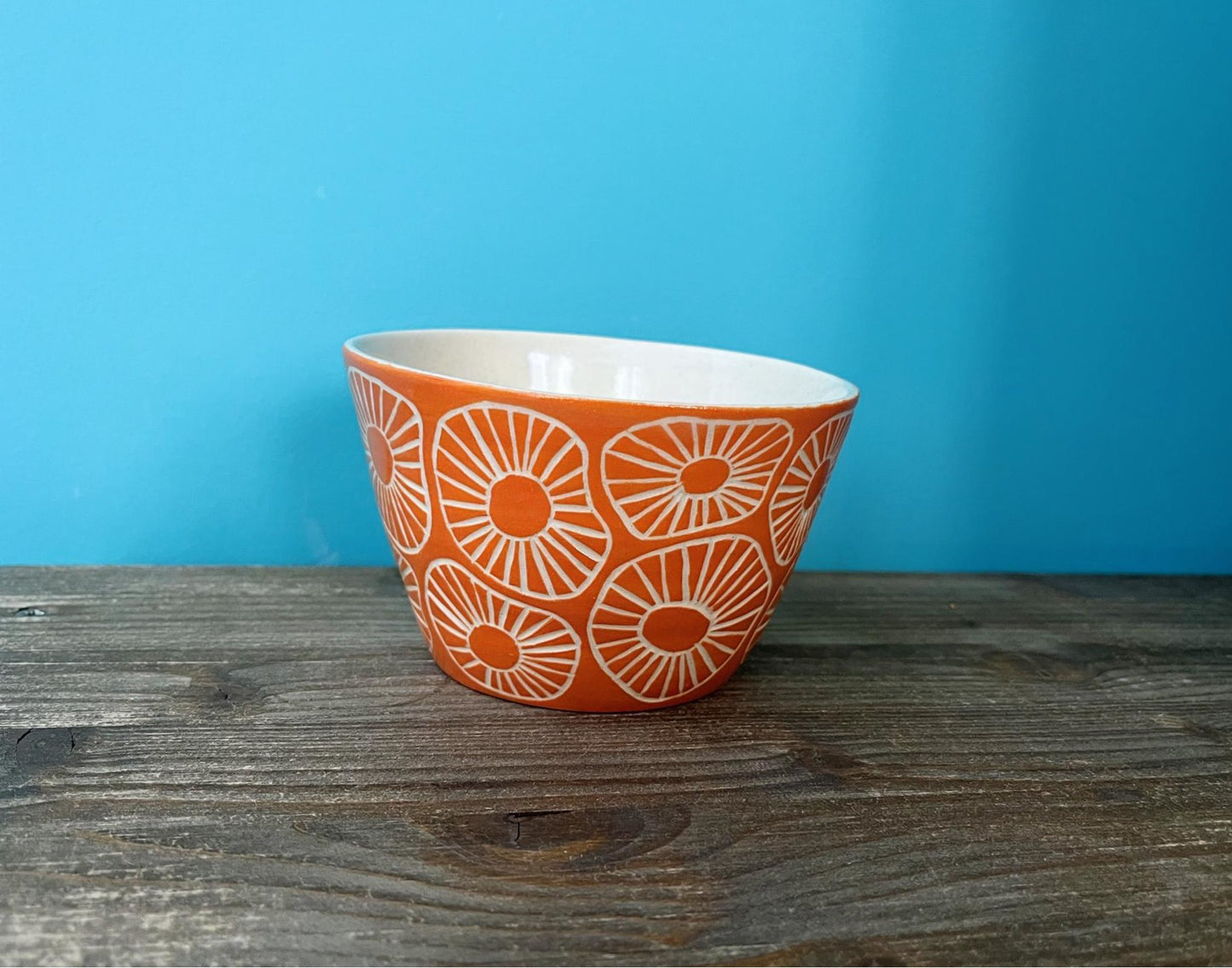 Maceta de cerámica naranja con textura esgrafiada