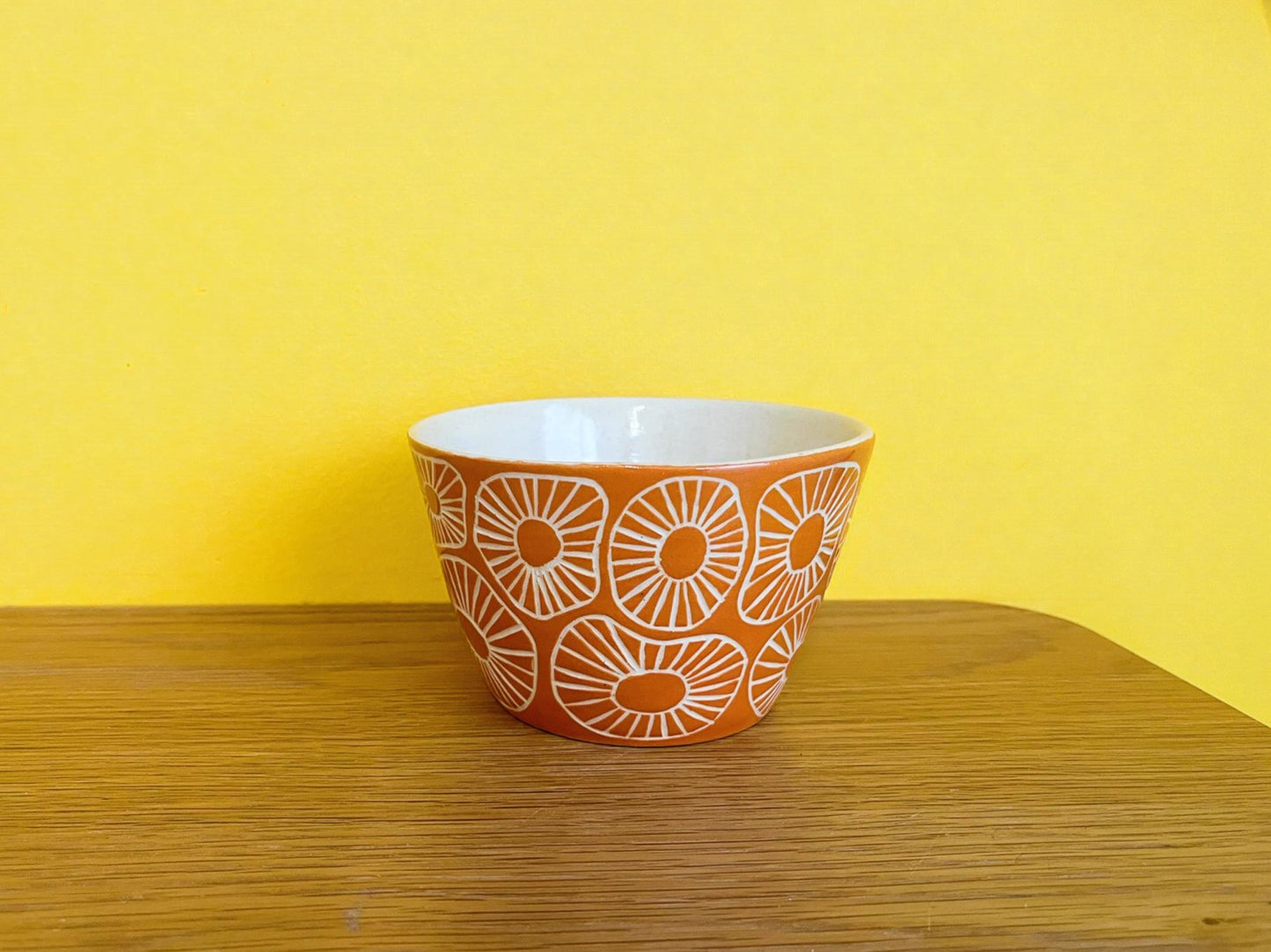 Maceta de cerámica naranja con textura esgrafiada