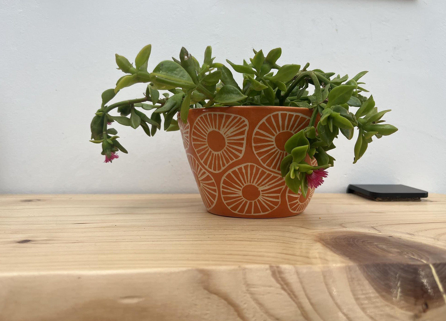 Maceta de cerámica naranja con textura esgrafiada